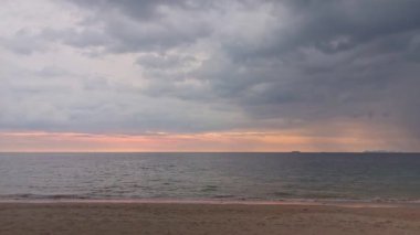 Long Beach, Ko Lanta, Thailand before the sunset. Waves hitting the beach and boat moving slowly in the distance.