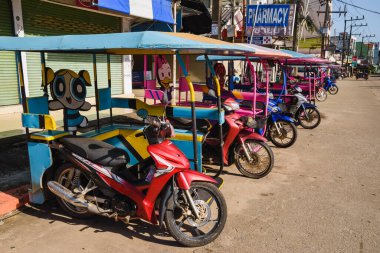 Typical tuk tuks of Koh Lanta. Cartoon themed motorbike taxis with sidecar parked in a row. Ko Lanta, Krabi, Thailand. November 30, 2022.