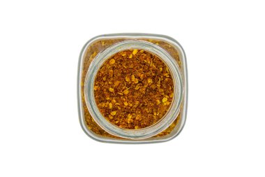 Chili powder in a glass jar, top view, isolated on white background