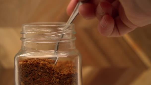 Taking Chili Powder Glass Jar Spoon Pouring Back Close — Stockvideo