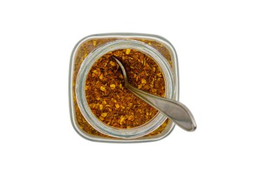 Cam bir kavanozda kırmızı biber tozu, beyaz arka planda izole, üst manzaralı.