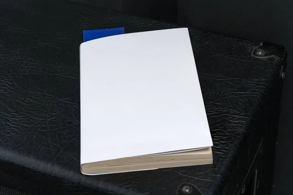 Blank white book cover template with blue bookmark on top of the black speaker cabinet. Clipping path.