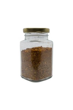 Chili powder in a glass jar with closed lid. Isolated on white background with clipping path.