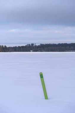 Finlandiya, Hollola 'da donmuş bir gölde yeşil seyir sporu şamandırası