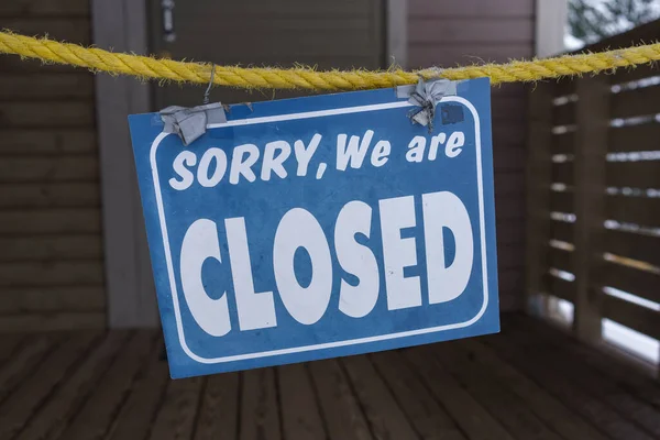 Sorry we are closed sign hanging on rope, close up