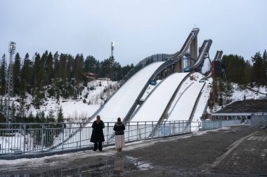 Lahti kayak kulelerinin önünde iki kişi vardı. Lahti Kayak Oyunları 'na hazırlanıyorum. Finlandiya. 19 Mart 2023.