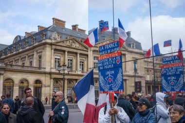 Paris, Fransa. 25 Mart 2023. Emeklilik reformunu protesto ederken, protestocular Palais-Royal 'ın önünde bir tabela tutuyorlar..
