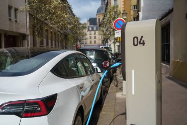 EV şarj istasyonundaki elektrikli araba Paris, Fransa caddesinde..