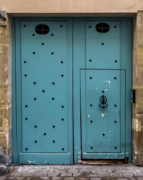 Old cyan double doors in Paris, France.