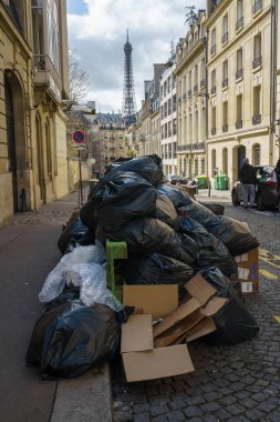 Paris, Fransa sokaklarında çöp yığını. Eyfel Kulesi de emeklilik grevi sırasında arka planda. 25 Mart 2023.