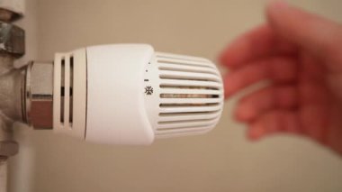 Kalorifer termostatını daha sıcak bir sıcaklığa ayarlayan el görüntüsünü kapat