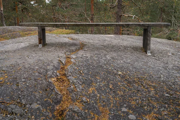 Wooden bench on top a rock in Finnish woods.