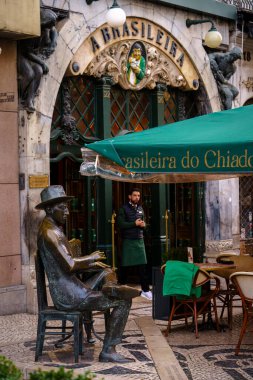 Brasileira do Chiado 'nun önündeki masada oturan bir adamın heykeli. Lizbon, Portekiz. 2 Şubat 2024.