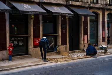 Portekiz, Lizbon 'da geleneksel fayanslı kaldırımı yenileyen iki işçi. 2 Şubat 2024.