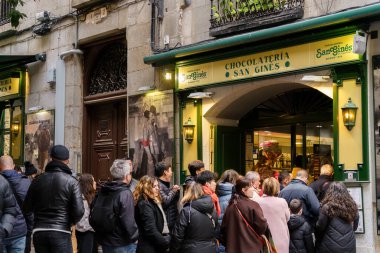 Madrid, Spain. February 11, 2024 - People waiting in line outside Chocolateria San Gines clipart