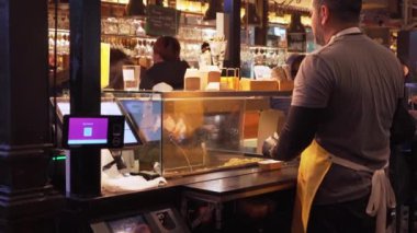 Madrid, İspanya. 11 Şubat 2024 - Mercado San Miguel 'de abur cubur ve tapas satan adam.