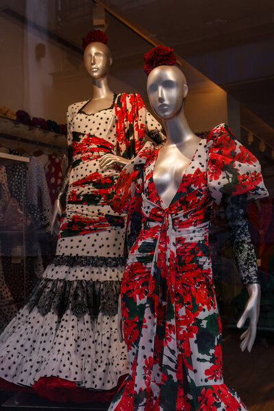 Seville, Spain. February 4, 2024 - Mannequins wearing red flamenco dresses on a store window
