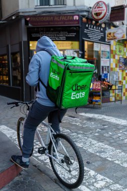 Sevilla, İspanya. 4 Şubat 2024 - Sevilla 'nın tarihi sokaklarında Uber Eats teslimatçısı bisikletçi