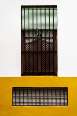 Geleneksel bir İspanyol penceresi, ahşap kepenkleri ve demir parmaklıkları var.