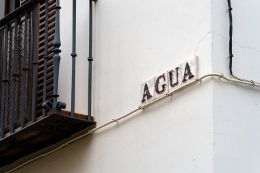 Sevilla, İspanya. 7 Şubat 2024 - Beyaz bir binanın üzerindeki Agua Caddesi tabelası