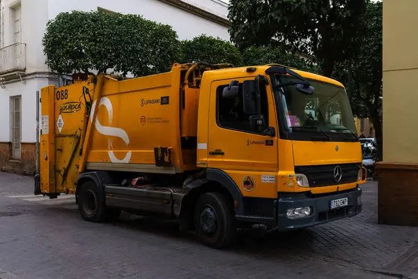 Stock image Seville, Spain. February 5, 2024 - Yellow garbage truck in a street