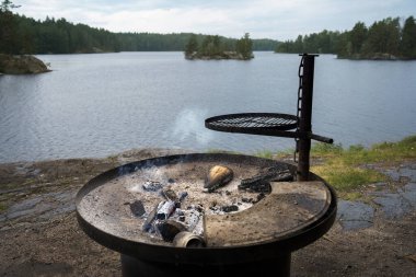 Finlandiya 'da göl kenarında ölen bir kamp ateşi.