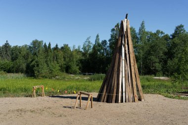 Kullanılmış tahtalardan yapılmış Finlandiya yaz ortası şenlik ateşi yakılmaya hazır