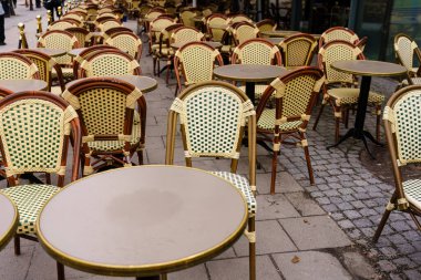 Boş hasır sandalyeler ve açık hava Avrupa kafesinde masalar bulutlu bir günde