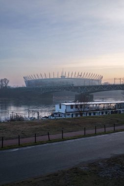 Varşova, Polonya. 27 Ocak 2025 - Ulusal Stadyum manzarası ve Vistula Nehri üzerinde bir demiryolu köprüsü