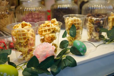 Brüksel, Belçika. 21 Mart 2025 Belçika Çikolata Fabrikası 'nın vitrininde nefis Belçika Waffle' ları sergileniyor..