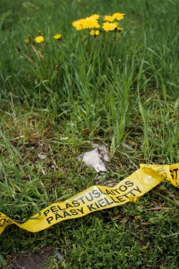 Çimenler üzerine sarı kurdele Fince: Pelastuslaitos Paasy Kielletty (Acil Servis Giriş Yasaktır).