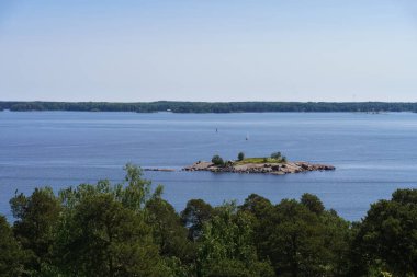 Finlandiya 'da yaz aylarında küçük kayalık bir adaya ev sahipliği yapan deniz manzarası