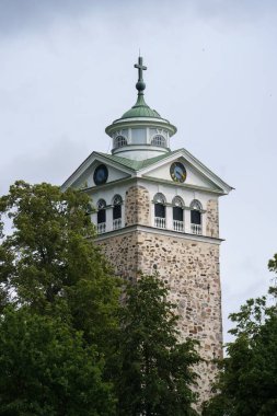 Raasepori, Finlandiya - 19 Haziran 2025 - Tammisari, Finlandiya 'da bulutlu gökyüzü ile Ekenas Kilisesi Kulesi