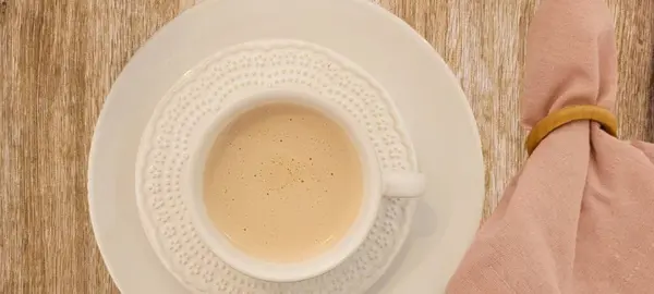 有牛奶咖啡 白杯和早餐茶托的木制餐桌 — 图库照片