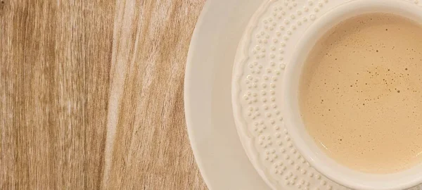 有牛奶咖啡 白杯和早餐茶托的木制餐桌 — 图库照片