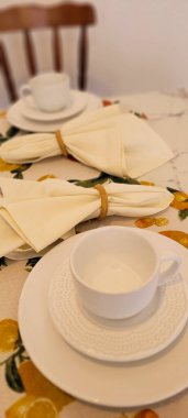 Beyaz bardak ve peçetelerle süslenmiş kahvaltı masası, limon tasarımlı tropikal masa.