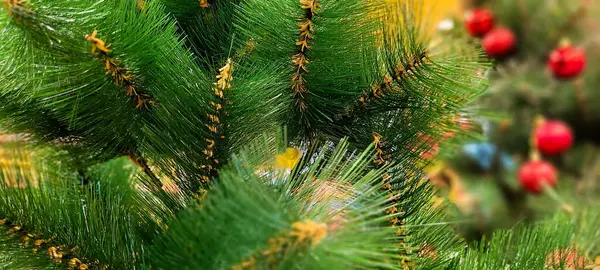 Topları, yıldızları, yeşil neşesi ve mutlu tatilleri olan renkli bir Noel ağacı.