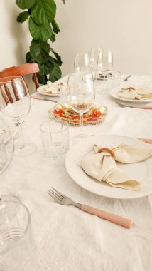 Tabaklar ve bardaklarla süslenmiş yemek masası.