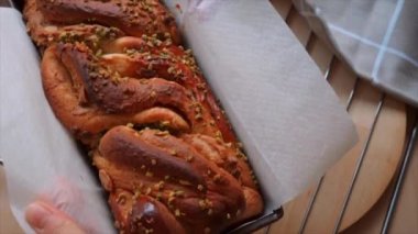 woman's hand removing freshly baked babka bread from a mold