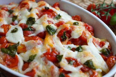 Italian baked pasta Paccheri with tomato, mozzarella cheese and fresh basil