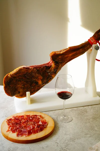 Spanish Jamn on a white jamonera stand and red wine glass