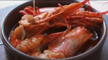 Çiseleyen sarımsak ve biber aromalı yağın Gambas al jillo (İspanyol sarımsaklı karides)