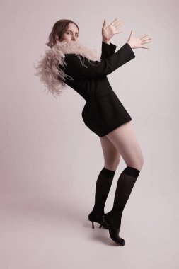 Beyaz duvarın üzerinde poz veren şık bir kadının stüdyo portresi. Dikey maket. Yüksek kalite fotoğraf