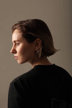 Beyaz duvarın üzerinde poz veren harika bir genç kadın. Dikey modelleme. İzole edildi. Yüksek kalite fotoğraf.