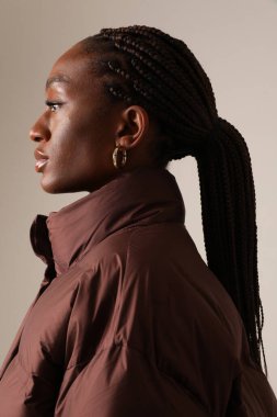 Warm and comfy. Young fashionable afro woman wearing down jacket. Vertical. High quality photo.