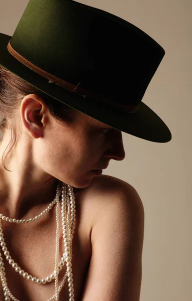 屋内ポーズ緑の帽子を身に着けている自信の若い女性の垂直肖像画 高品質の写真 — ストック写真