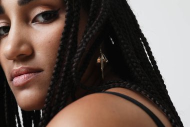 African American young woman with long dark braids, posing indoor. Mock-up. High quality photo