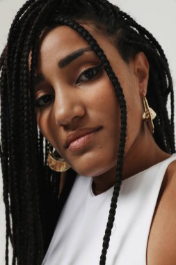 African American young woman with long dark braids, posing indoor. Mock-up. High quality photo