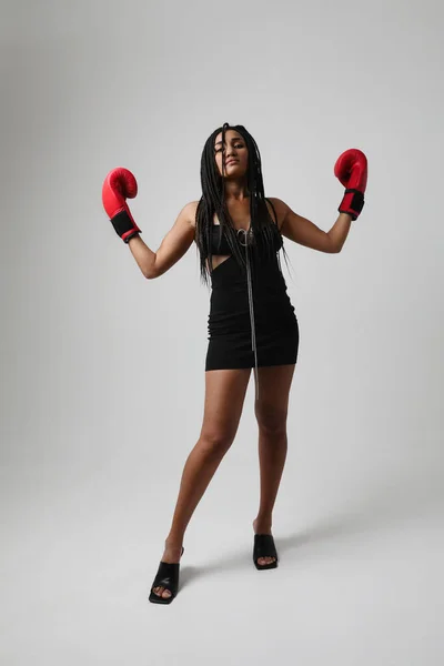 Powerful woman. Young African American woman with red boxer glows posing indoor. High quality photo.