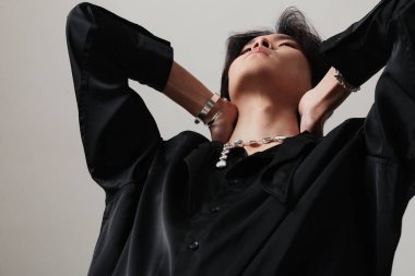 Cropped portrait of young man with earrings posing over white wall. Mock-up. High quality photo.